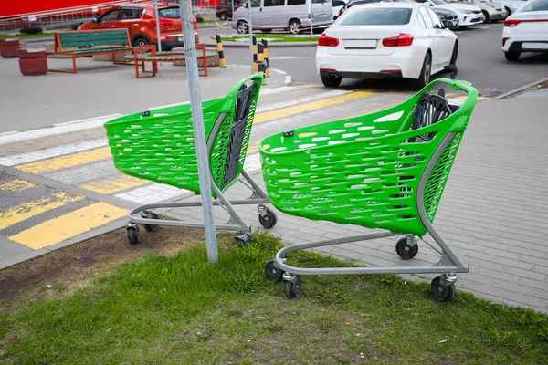 Chariots verts près du passage pour piétons en arrière-plan d'un parking pour voitures. — Photo