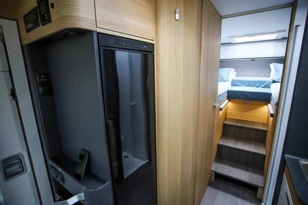 Zelten im Wohnwagen, Wohnküche und Schlafzimmer, niemand. Mobile Küche und Garderobe im Wohnmobil. Das Leben im Mobilheim. — Stockfoto