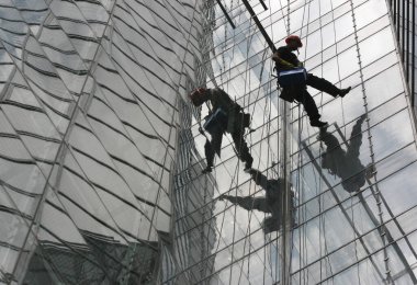 Beyaz Rusya. Minsk - 22,06,2009: İşçi, endüstriyel tırmanışçı, cam temizleme servisi Belarus Ulusal Kütüphanesini yıkadı.