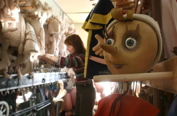 ベラルーシ。ミンスク- 12,03,2010:人形ワークショップの従業員が公演前に人形を調べるドレッシングルームのピノキオ人形. — ストック写真