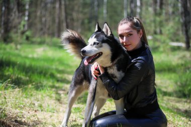 Şirin kız bir Husky 'ye sarılıyor. Husky çok iyi arkadaştır..