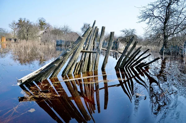 Bielorrússia. Petrikov - Abril de 2013: Inundações na aldeia. Cerca inundada na primavera, inundação. — Fotografia de Stock