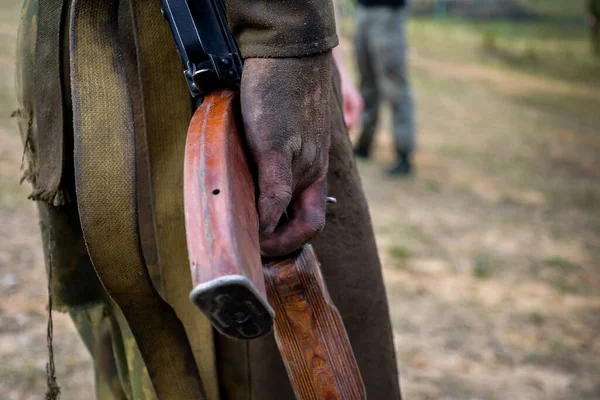 Białoruś. 22,04,2014: Karabin maszynowy w brudnej ręce człowieka. Żołnierze jednostek specjalnych są testowani pod kątem prawa do noszenia bordowego beretu. Wojsko — Zdjęcie stockowe