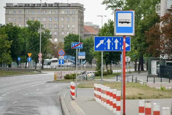 WARSAW. POLONIA - AGOSTO 2015: Señalización de dirección de carril, señal de parada de transporte público, postes de valla roja y blanca. — Foto de Stock