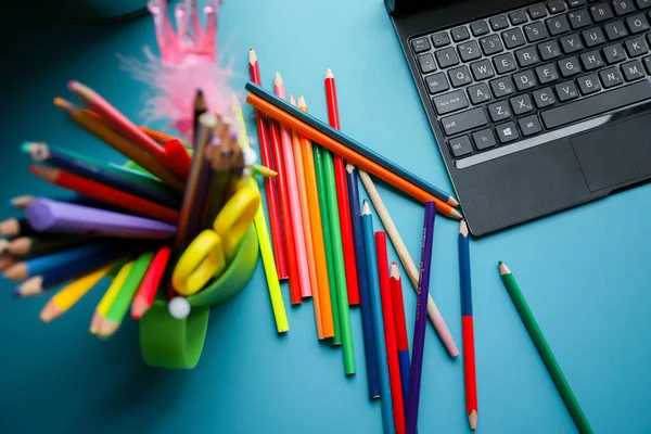 Crayons de couleur dans un cercle vert sur une table bleue. Beaucoup de crayons de couleur différents. Papeterie. — Photo