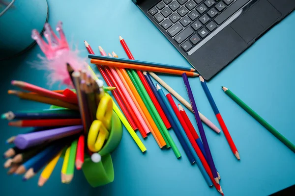 Lápis coloridos em um círculo verde em uma mesa azul. Muitos lápis de cor diferentes. Papelaria. — Fotografia de Stock