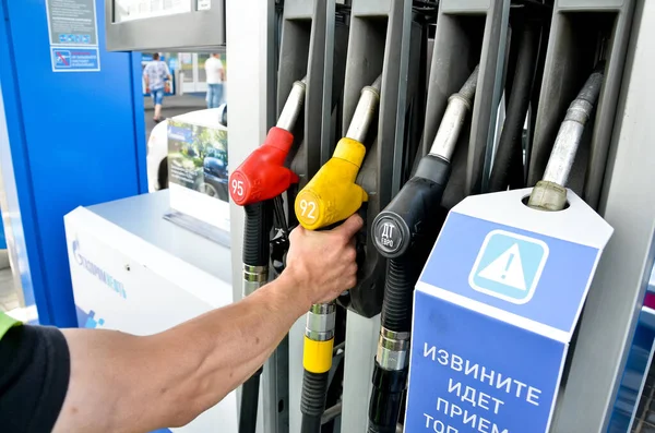 MINSK. BELARUS: 13.06.2013 - Gasolinera. La pistola de reabastecimiento está en la solapa de llenado de combustible de los coches azules. — Foto de Stock