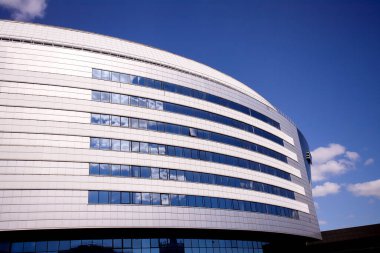 The new building of the sports complex against the blue sky. Glass windows and sky.
