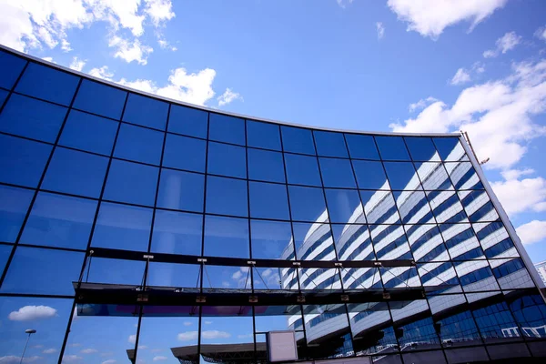 The new building of the sports complex against the blue sky. Glass windows and sky. — Stockfoto