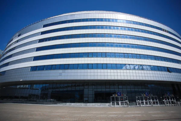 The new building of the sports complex against the blue sky. Glass windows and sky. — Stock Photo, Image