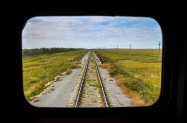 Rusya - 02.09.013 - Raylardaki tren penceresinden, bozkırlardan ve bulutlardaki gökyüzünden görüntü.