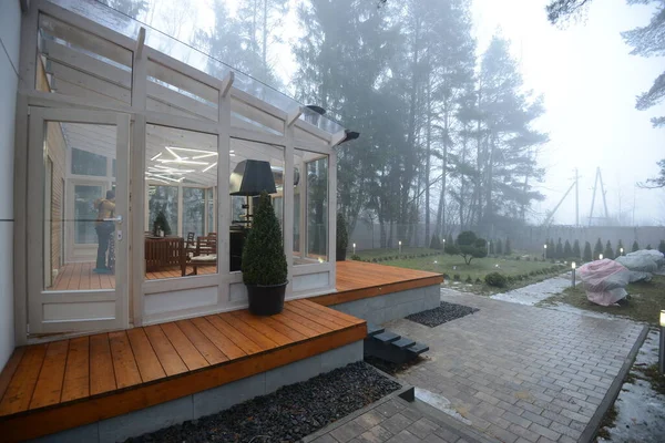 Bielorussia - 26.02.2015 - Terrazza in vetro con vista sulla foresta nebbiosa. Casa propria nella foresta. — Foto Stock