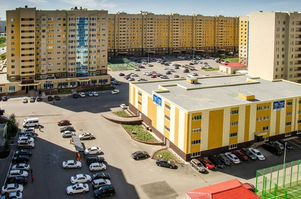 Nur-Sultan. Kazakhstan: 04.09.2013 - Parking in the residential center. Residential buildings are yellow, a residential complex against a blue sky. Nur-Sultan. Kazakhstan. — Stock Photo, Image