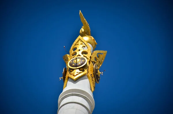 Nur-Sultán. Kazajistán: 04.09.2013 - Monumento de oro en el cielo azul. Una estatua de oro sobre un clon de mármol blanco. — Foto de Stock