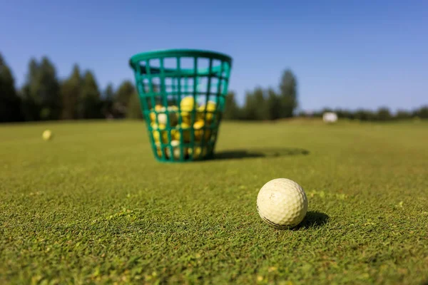 Cesta de bolas de golfe em um campo — Fotografia de Stock