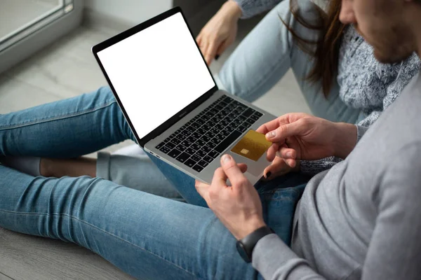 Großaufnahme eines Laptops in den Händen eines Mannes, der mit Kreditkarte online bezahlt lizenzfreie Stockfotos