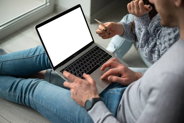 Primer plano de la computadora portátil en manos de un hombre, pagando con tarjeta de crédito en línea — Foto de Stock