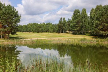 Golf kulübünün çevresi yeşilliklerle çevrili.