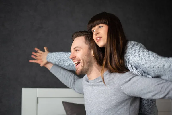 Young man and woman hugging in bed with a white headrest. — Stock Photo, Image