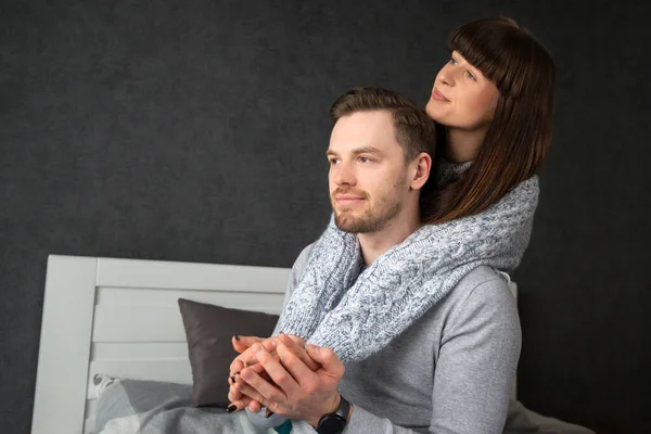 Jongeman en vrouw knuffelen in bed met een witte hoofdsteun. — Stockfoto