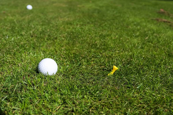 Bola de golfe no fundo grama verde — Fotografia de Stock