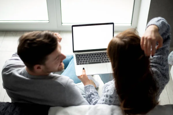 Fiatal család belenéz egy laptopba, örül — Stock Fotó