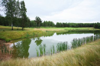 Golf kulübünün çevresi yeşilliklerle çevrili.