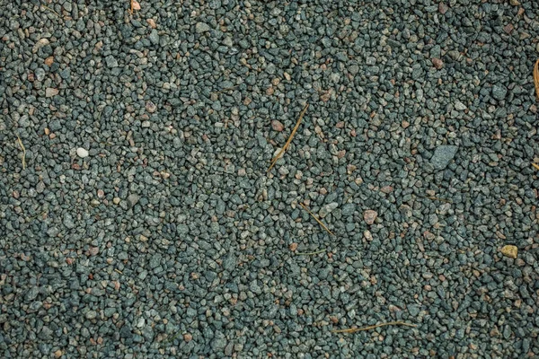 Bakgrund, små stenar av grå färg på marken — Stockfoto