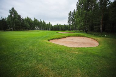 Ormanın ortasındaki golf sahasında kum tabakası.