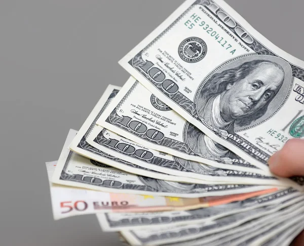 Many dollars falling on man's hand with money — Stock Photo, Image