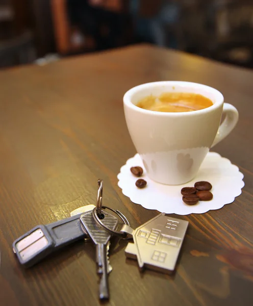 Taza de café en el escritorio y llaves — Foto de Stock