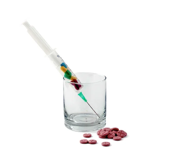 Medyczne strzykawki witn pigułki i szklane biurko, na białym tle — Zdjęcie stockowe