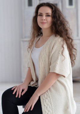 Bir sandalyede oturan mutlu esmer kız