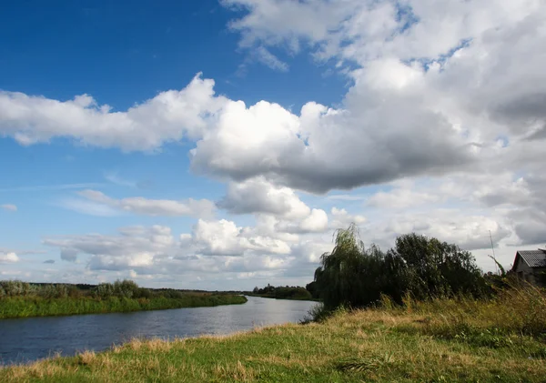 Vue sur la rivière avec reflets et ciel nuageux bleu — Photo