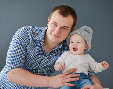 Mutlu baba oğul gri arka plan üzerinde izole taşıyan