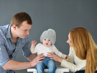 Koyu arka plan üzerinde siting mutlu genç çift küçük bebeğim