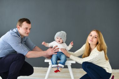 Koyu arka plan üzerinde siting mutlu genç çift küçük bebeğim