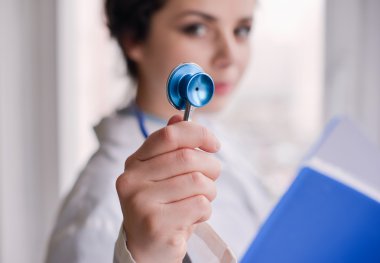 Kadın doktor klasör konumu penceresinde yakınındaki olan stetoskop kullanarak