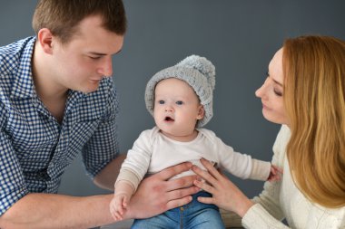 Koyu arka plan üzerinde siting mutlu genç çift küçük bebeğim