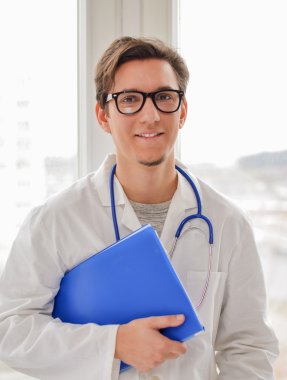 Erkek doktor ile klasör penceresinin yanında ayakta