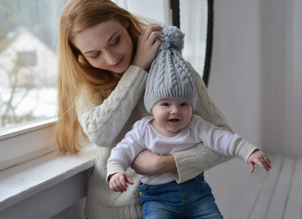 Portrait of happy mother and baby, sitting near window — Stock Photo, Image