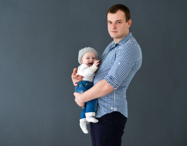 Mutlu baba oğul gri arka plan üzerinde izole taşıyan