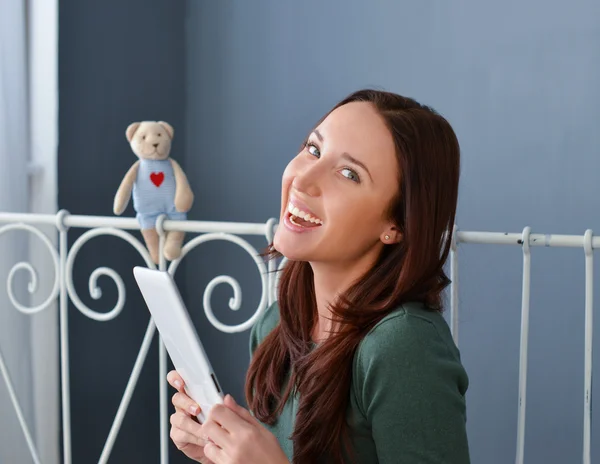 Young woman using plane-table on her bed — Stock Photo, Image