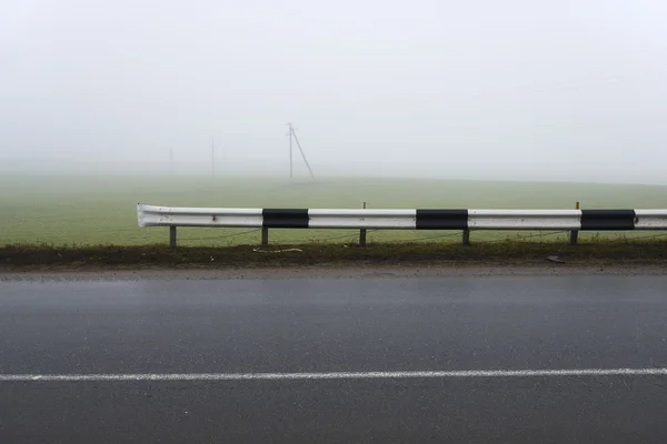 Asphaltstraße bis zum Horizont bei bewölktem Himmel — Stockfoto