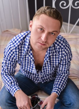 Adam sandalyede oturan süet ayakkabılarını bağlama