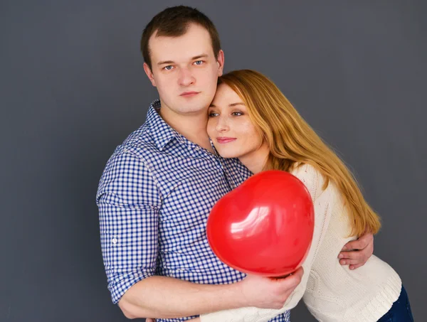 Piękna para zakochani w kształcie serca czerwony balon na Walentynki, na szarym tle — Zdjęcie stockowe