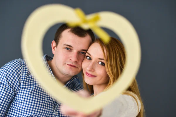 Vackra par i kärlek med rött hjärta form för alla hjärtans dag, på grå bakgrund — Stockfoto