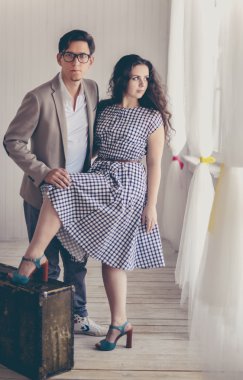 Çekici genç çift ayakta yakınındaki eski bir bavul 