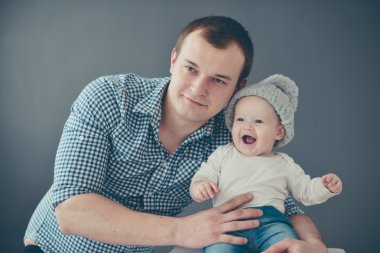 Mutlu baba oğul gri arka plan üzerinde izole taşıyan