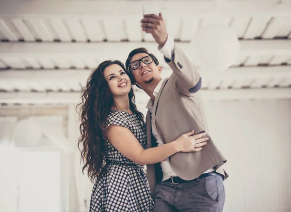 Casal tirando uma foto com seu telefone celular enquanto — Fotografia de Stock